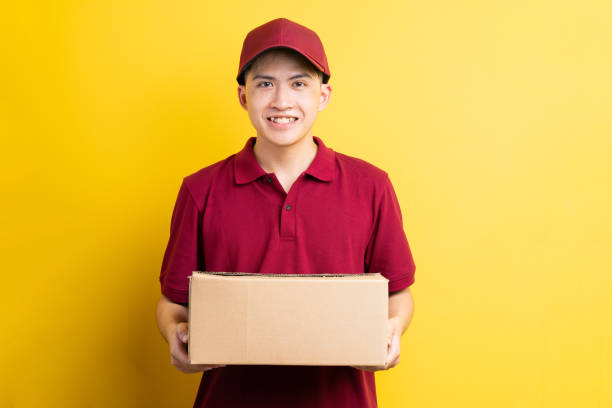istock Asian delivery man portrait, isolated on yellow background 1323808065