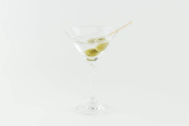 istock Martini cocktail with green olives on white background 1323812753