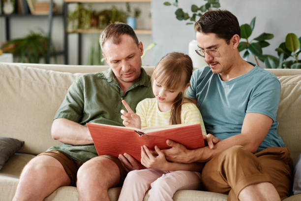 istock Gay parents reading a book to child 1323814926