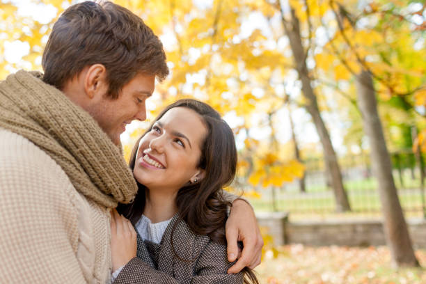 istock smiling couple hugging in autumn park 1323816407