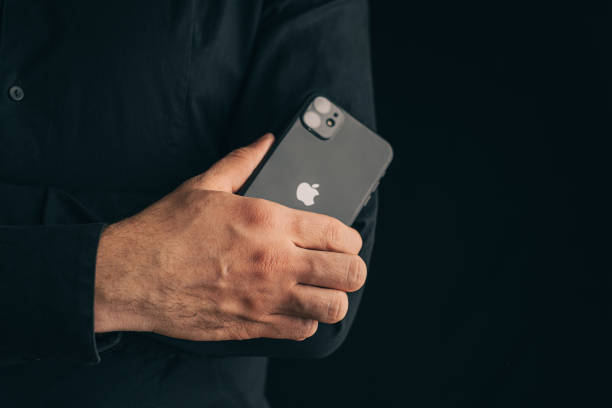 Man folding his arms cross to cross on his chest with iphone 11. stock photo