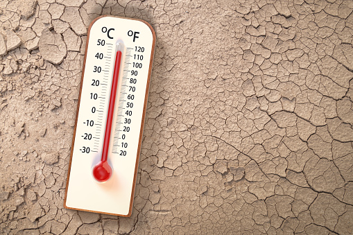 Top view Thermometer on Dry soil ground cracks background texture show higher Weather, concept global warming, climate change