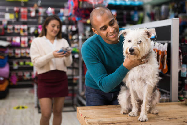 istock Emotional man hugging dog in pet store 1323823621