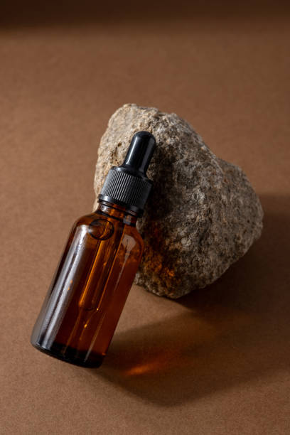 istock One brown serum glass bottle with pipette , stone composition on brown background. Natural Organic Spa Cosmetic concept. 1323825838