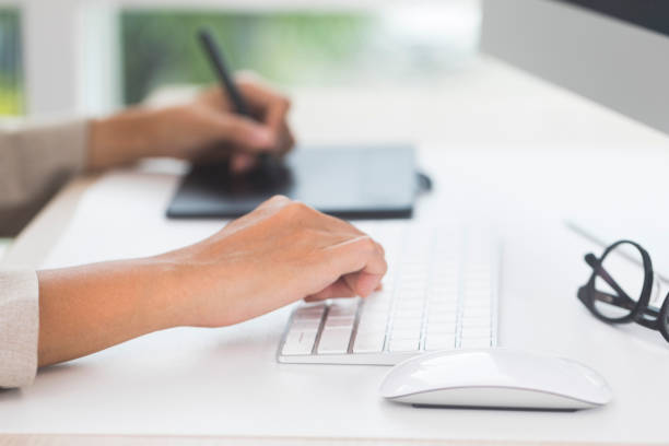 istock Designer's hand holding pen and working with graphics tablet. 1323829710