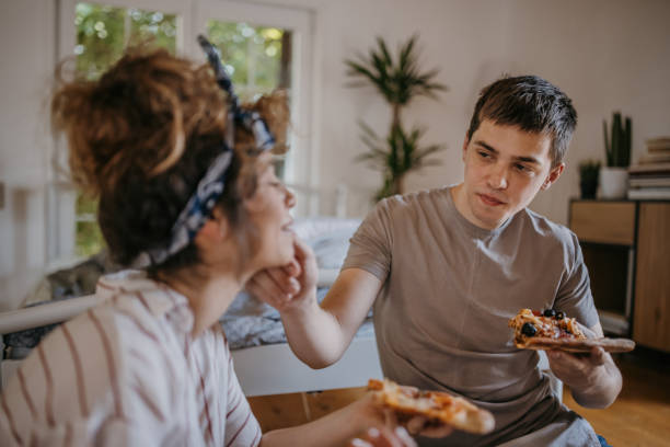istock Couple playing eating pizza at home 1323833023