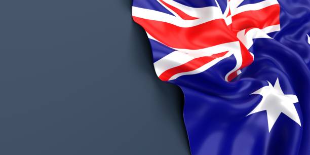istock Australian Flag is Waving Against Blue Gray Surface 1323834160