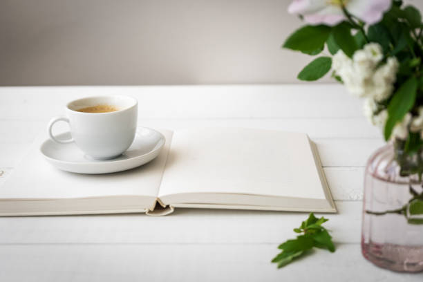 istock A cup of coffee on an open book and fresh flowers 1323838678