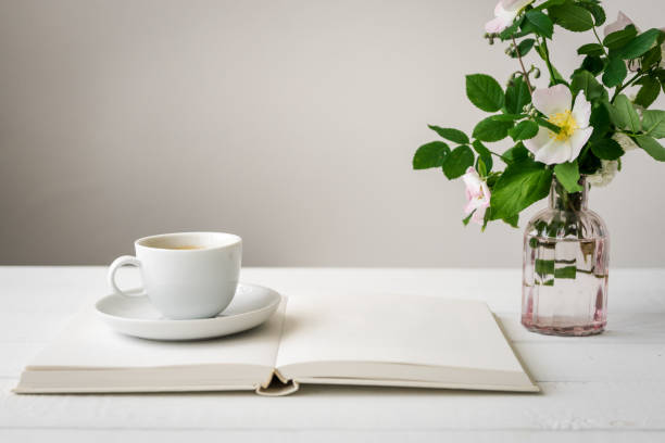 istock A coffee cup, fresh flowers and an open book on a table 1323838729