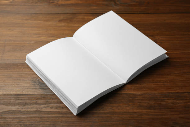 istock Open blank paper brochure on wooden table. Mockup for design 1323839368