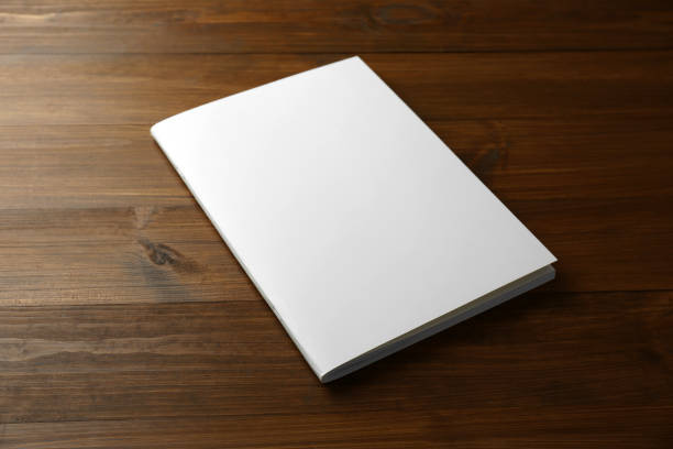 istock Blank paper brochure on wooden table. Mockup for design 1323839496