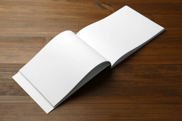 istock Open blank paper brochure on wooden table. Mockup for design 1323839517