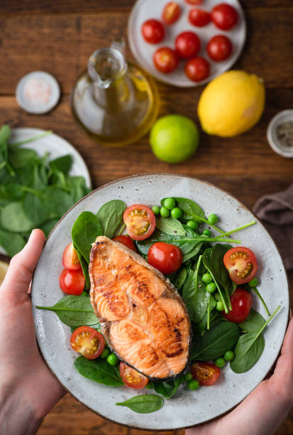 istock Healthy dinner meal with roasted salmon steak and spinach salad 1323841905