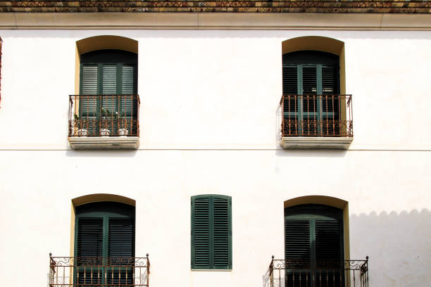 istock Whitewashed facade with window with forged metal grill 1323843300