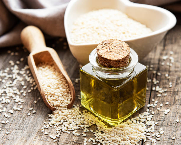 istock Sesame oil and seeds on a rustic table. 1323843719