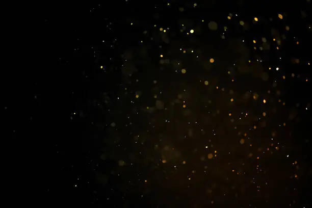 Photo of texture of gold dust or drops on a black background, overlay