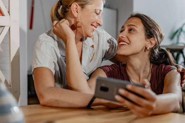 istock LGBT Lesbian couple relaxing at home and using mobile phone 1323846397