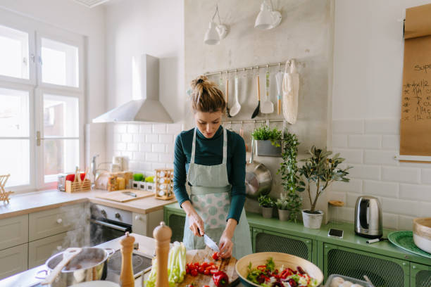 istock Young woman cooking in her kitchen 1323846512