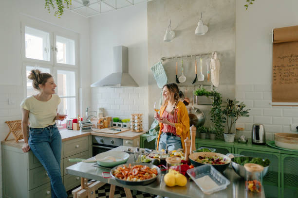istock Young women cooking dinner and drinking wine 1323847681