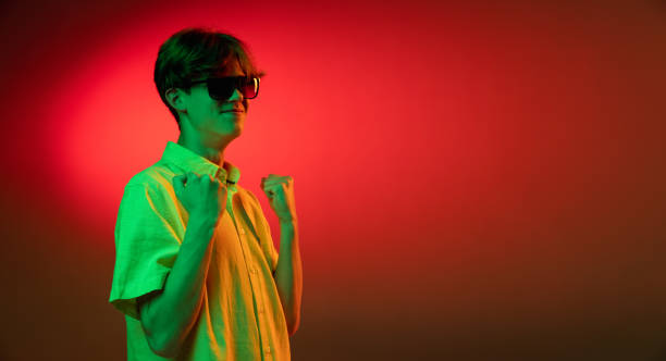 istock Crazy happy winner. Young caucasian man's portrait on gradient blue-pink studio background in neon light. Concept of youth, human emotions, facial expression, sales, ad. 1323848879