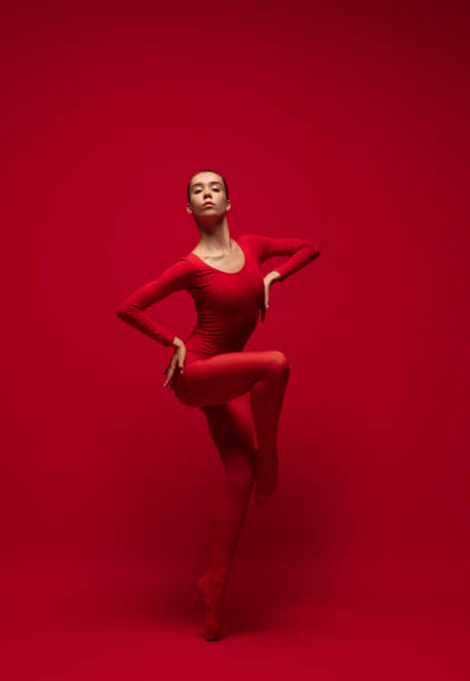 grácil joven hermosa chica, bailarina de ballet posando aislada sobre fondo rojo. - contemporary ballet fotografías e imágenes de stock