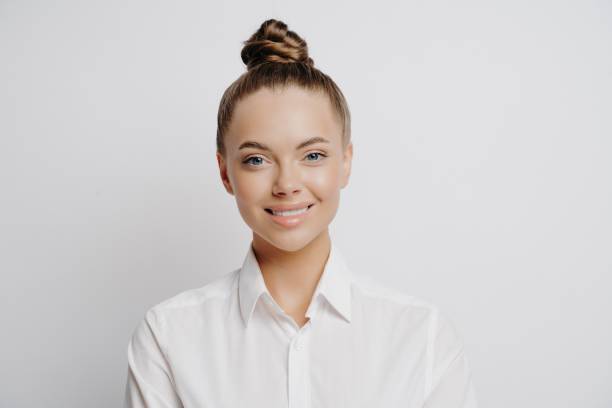 feliz sucesso mulher de negócios de camisa branca posando em estúdio - hair bun - fotografias e filmes do acervo