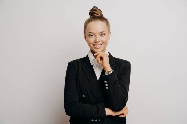 istock Happy female office worker with hand on chin 1323849319