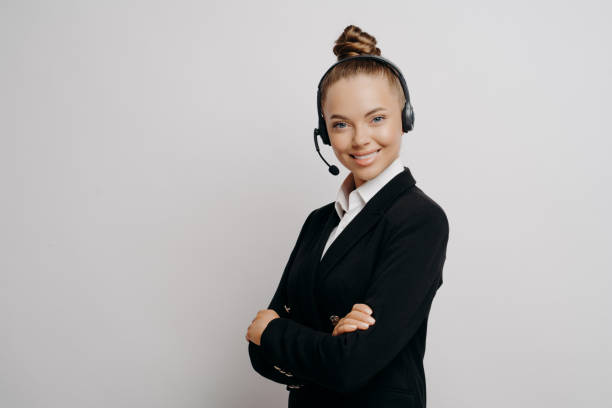 istock Friendly business woman in headset in dark suit ready for web conference 1323849337