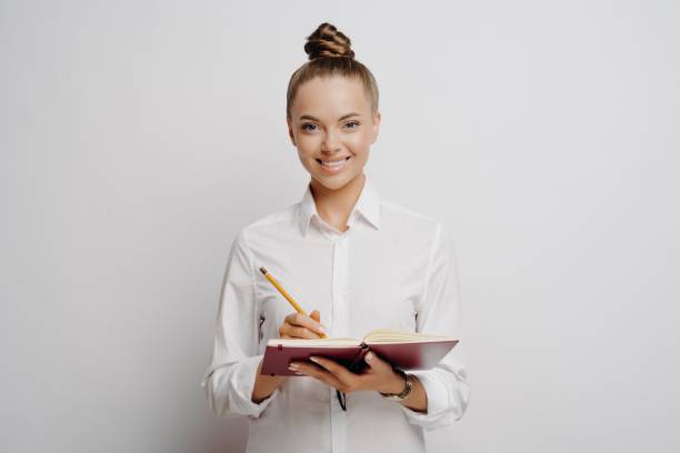 istock Business professional in white shirt writing down ideas in note book 1323849348