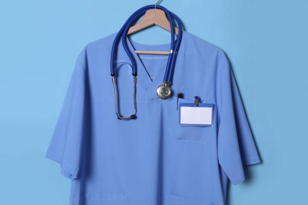 camicia da dottore con stetoscopio, badge e penna appesi su sfondo azzurro - penna tasca foto e immagini stock
