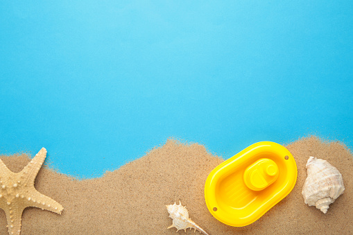 Summer beach toys with accessories on blue background. Top view