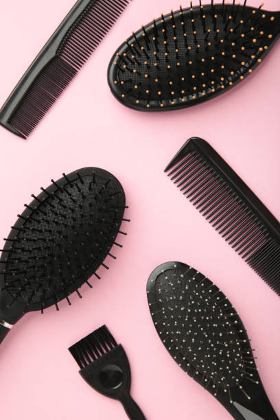 istock Hair tools, beauty and hairdressing concept - different brushes or combs on pink background. 1323850997