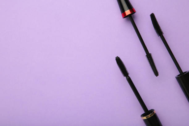istock Various mascara wands on purple background with copy space 1323851020