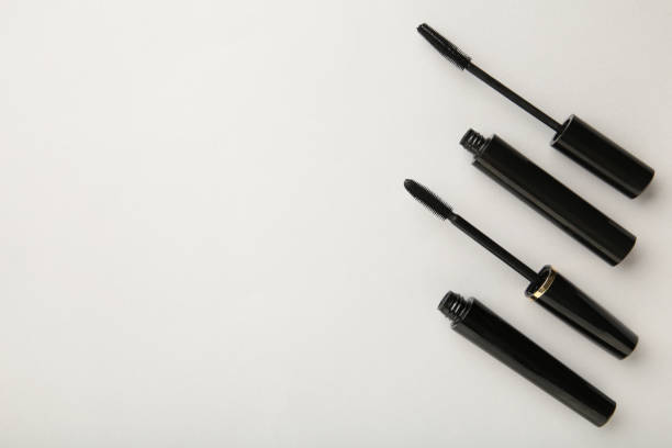 istock Black mascara wand and tube on grey background with copy space 1323851964