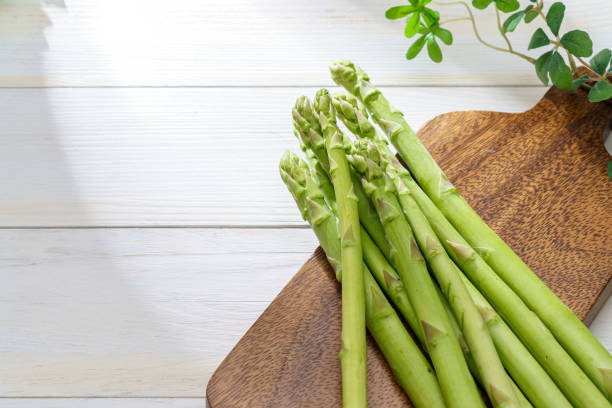 istock Green asparagus isolated on wooden table 1323852356