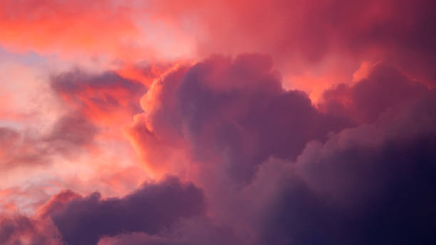 istock Intense vibrant dramatic cloudscape scenery with clouds lit up in various shades of contrasting pink and magenta against at blazing sunset. 1323852976