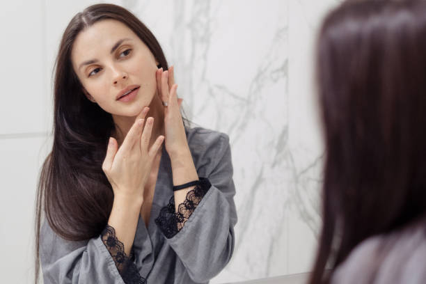 istock Brunette doing face massage with hands in bathroom 1323855216