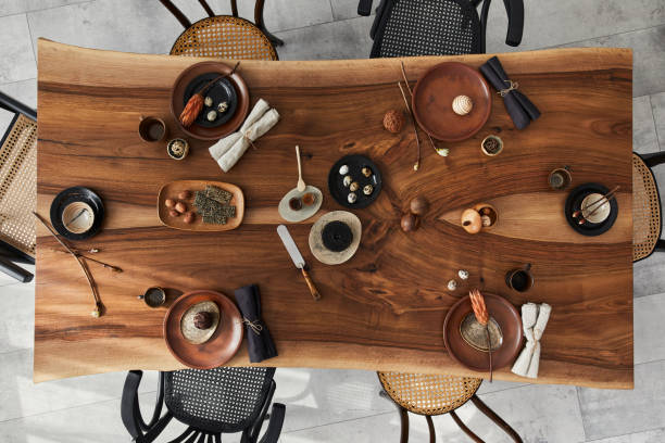 Stylish interior design of dining room with wooden walnut table. Template. Top view. Stylish interior design of dining room with wooden walnut table, decoration and elegant accessories. Cement floor. Template. Top view. dining table stock pictures, royalty-free photos & images