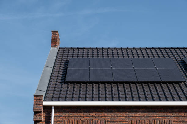 日当たりの良い空に対して屋根に取り付けられたソーラーパネルを備えた新築住宅黒いソーラーパネルで新しい建物を閉じます。ゾンネパネン、ゾンネエナギー、翻訳:ソーラーパネル、太陽 - energie ストックフォトと画像