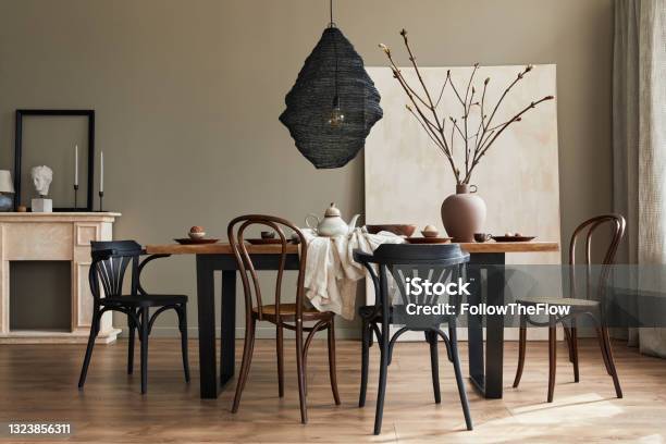 Stylish Rustic Interior Of Dining Room With Walnut Wooden Table Retro Chairs Pedant Lamp Fireplace Dried Flower Candlestick Mock Up Picture Frame And Carpet In Minimalist Home Decor Template Stock Photo - Download Image Now