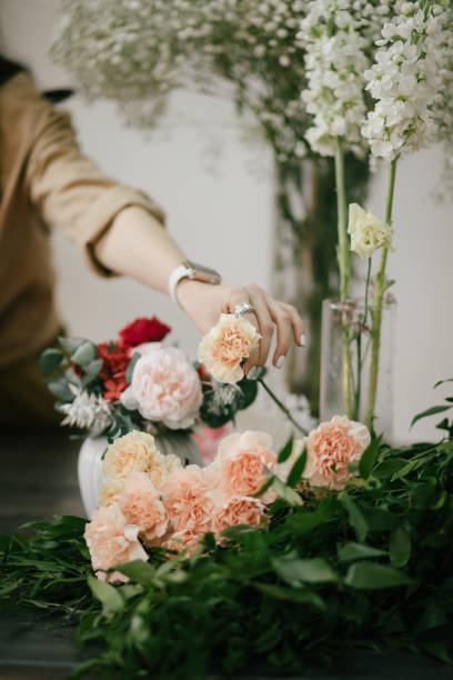 istock Young woman florist working in her flower studio, making beautiful bouquet using fresh plants and flowers. 1323857329