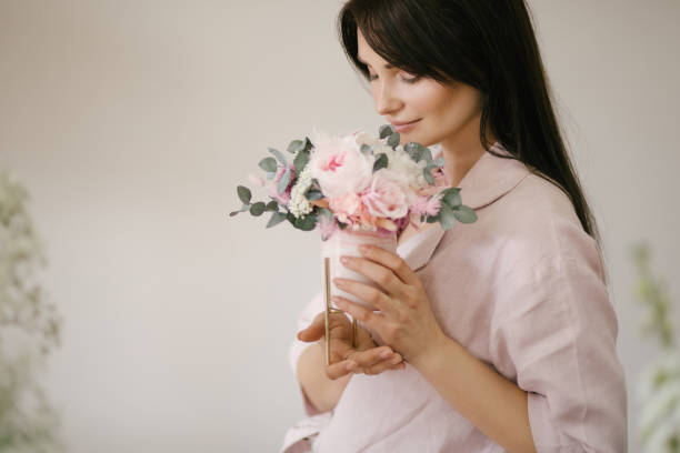 istock Young woman florist working in her flower studio, making beautiful bouquet using fresh plants and flowers. 1323857330
