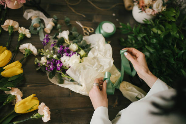 istock Young woman florist working in her flower studio, making beautiful bouquet using fresh plants and flowers. 1323857345