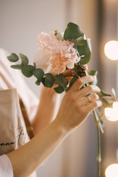 istock Young woman florist working in her flower studio, making beautiful bouquet using fresh plants and flowers. 1323857346