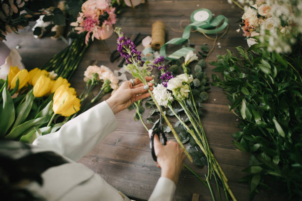 istock Young woman florist working in her flower studio, making beautiful bouquet using fresh plants and flowers. 1323857355