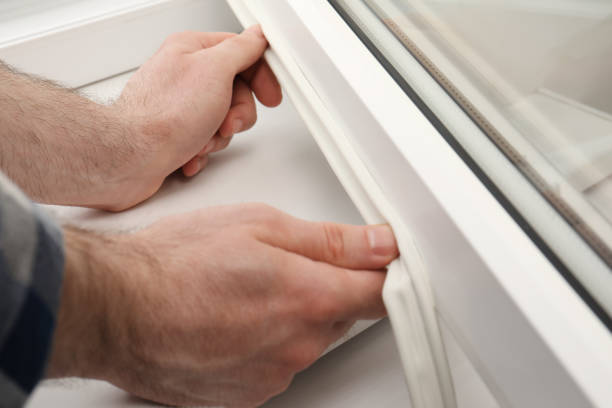 istock Worker putting rubber draught strip onto window indoors, closeup 1323857620