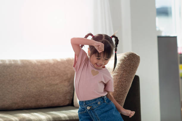 istock Happy Asian child having fun and dancing in a room 1323859197