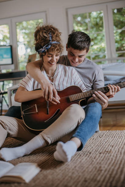istock Boyfriends teaching girlfriend to play guitar 1323859439