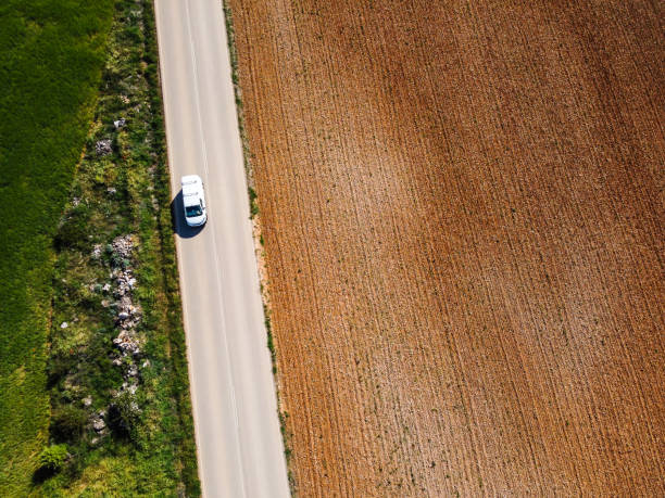 istock A lonely car is driving by a road amidst farm fields 1323860945