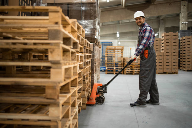 istock Caucasian warehouse worker lifting weight with manual pallet jack. Working in storage room. 1323861030